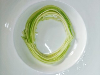 6、捞汁西葫芦,取一缕微微修剪长短,围成半圆,再取一缕围另一半,使他成为圆形