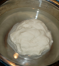 3、自制凉皮/面筋,找一个稍大的盆，放半盆冷水，把面团放进去象洗衣服一样的揉。