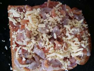 4、土司披萨#健康美颜餐#,将小虾仁和海米撒在上面在均匀的撒上一层马苏里拉奶酪碎