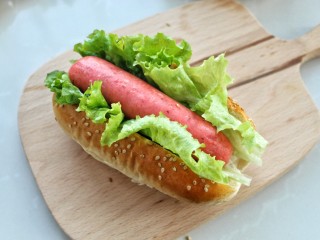 13、热狗面包,在面包上面切开，注意不要切断底部，然后夹上生菜叶和烤好的热狗肠