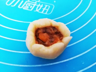 9、咸蛋黄肉松一口酥,取一份面团压扁，上面挖一点馅料，收口收紧，搓圆