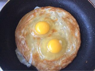 2、自创手抓饼披萨,手抓饼两面分别煎半分钟后打上鸡蛋2个，用木铲摊开，