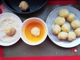 6、芝士虾球,包好的土豆虾球，沾一层蛋液，裹一层面包糠，放在刷了油的烤盘。