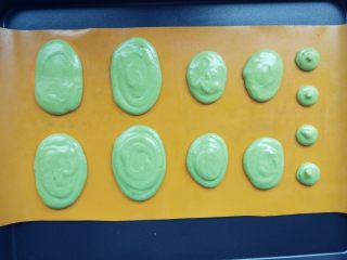 14、抹茶仙人掌马卡龙,装入剪口的裱花袋中，在硅胶垫上按照纸片图案挤出合适大小