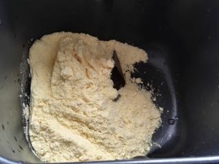 1、芝麻玉米面白糖饼,玉米面倒容器中（本来想蒸玉米面窝头，临时改变主意做饼，感觉量多馒头机和不下又倒出用手揉的）。