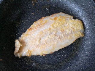 12、家庭版自制烤鱼,锅中适量油烧热,给腌制好的龙利鱼外面薄薄裹一层裹炸粉后入锅。中小火煎至两面金黄挺实后盛出备用。