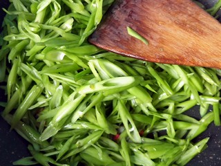 7、蒜蓉空心菜梗,倒入空心菜梗翻炒。