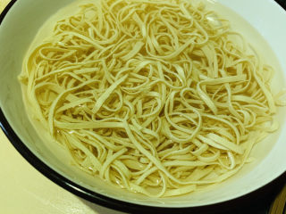 8、凉拌千张,准备一碗凉白开水，将捞好的千张泡着