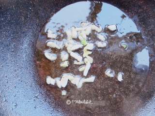 4、虎皮青椒,直接在锅中放入适量的凉油, 加入准备好的蒜末葱花,慢慢地煸炒出香味来