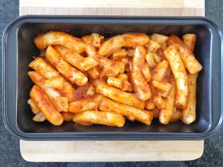 15、芝士辣烤年糕,接下来，找一个可以进烤箱的容器，把软糯的年糕加进来，