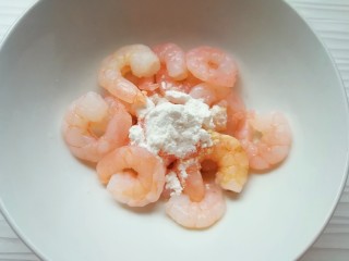 2、甜豆红萝卜炒虾仁,加入白酒、鲜贝露、玉米淀粉和2g食用油搅拌均匀，腌制10分钟左右。