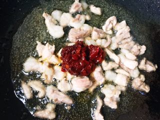 5、#酸味#家常酸菜肉丝面,肉变色立即加入适量豆瓣酱翻炒均匀。