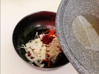 18、香辣海带丝,趁热把大豆色拉油倒入盆中，把大蒜和辣椒粉的香味激发出来