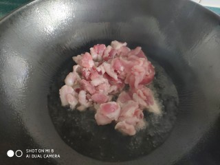 7、家常五花肉炒土豆,炒锅油热后放入五花肉片翻炒。