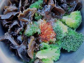 6、西兰花拌木耳,起锅热油，把油烧到十成热，慢慢浇在面上。只听呲啦一声，香飘四溢，拌均即可！