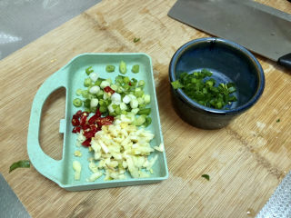 4、水煮千张,小葱切末葱白葱叶分开，小米辣切圈，姜切末，蒜切蒜蓉