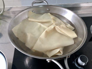 9、水煮千张,坐锅烧水，水开，下豆腐皮，煮约一分钟
