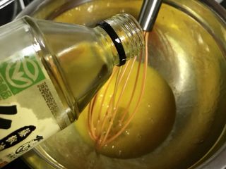 3、Lékué模藤椒戚风蛋糕,加入15g藤椒油,玉米油,用手动打蛋器搅拌至蛋黄乳化。