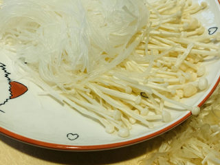 14、粉丝蒸金针菇,将带有菇帽的部分摆放在粉丝周围;