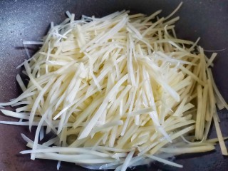 7、醋溜土豆丝,转大火放入土豆丝翻炒至透明。