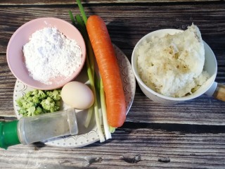 1、饭团子,准备食材，一碗米饭，胡萝卜，小葱，糯米粉，胡椒粉，一颗鸡蛋，西兰花，花生米，芝麻等