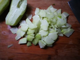 2、青蒜焦香佛手瓜,削去皮，用刀贴着凹槽两面皮划切两刀，挖出凹槽片，挖出里面种子，切成薄片