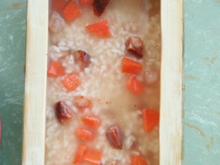 4、竹筒饭,将泡好的米、切成丁的食材，加一点耗油，一并放到竹筒内，（因为米已经泡一天啦，所以水可以少放。）