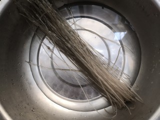 6、豆芽炒粉条,粉条放入盆中，倒入热水，泡软