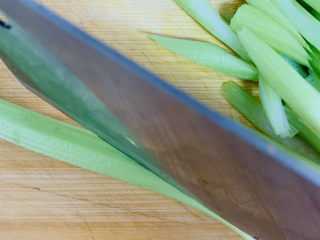 4、芹菜炒胡萝卜,芹菜清洗干净，斜刀倾斜切成0.5厘米厚的条。