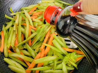 12、芹菜炒胡萝卜,加入适量的酱油翻炒。