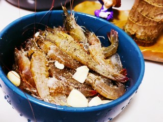 2、四川冒菜,去虾线和虾囊，然后背部劈开，加入料酒，盐，蒜瓣和黑胡椒粉，搅拌均匀腌制20分钟