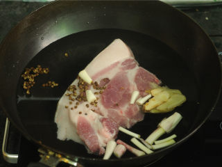 2、酱烧回锅肉,锅中放入清水,然后放入葱段、黄酒、八角、5克花椒、十克姜片,冷水放入猪肉,大火煮开
