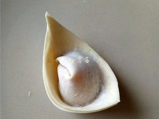 7、四川抄手,再将两个角粘起来；将抄手角粘起来时，可借助肉馅，或蛋清；