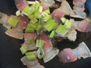 3、苦瓜炒腊肉,待腊肉出油后，放大葱翻炒。