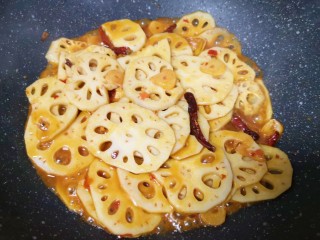 7、干锅藕片,加入半碗开水，放原味鲜酱油和糖调味，翻炒至藕片变熟汤汁基本上收干。