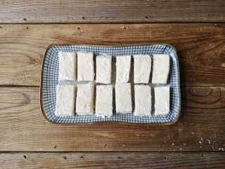 5、咕咾豆腐,拍好裹炸粉的豆腐条静置几分钟，让裹炸粉完全粘在豆腐的外表。