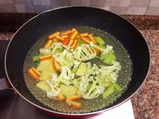 4、什锦干锅,烧一锅开水,将花菜、土豆、莴苣、胡萝卜焯水一分钟,捞出沥干水份备用。