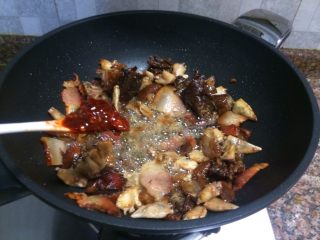 9、什锦干锅,放入豆瓣酱翻炒10秒。