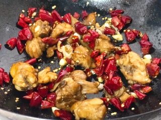 6、辣子鸡,下入炸好的鸡块，放入白砂糖，香醋，倒入适量清水，翻炒