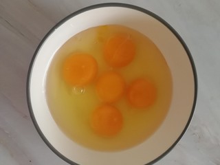 4、油炸酥肉,制作面糊，把剩下的4个鸡蛋打入碗中（有一个是腌肉剩的蛋黄）