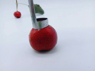 7、零添加山楂罐头,再用去核工具再山楂的顶部用力压下去，如图。