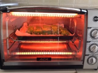 17、秘制烤辣椒,把烤盘放入预热好的烤箱里，上下火200W烤10分钟