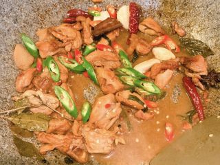 13、农家小炒鸡,放入青辣椒，红辣椒，蒜，翻炒均匀，即可出锅