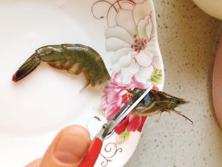 2、香甜辣味虾-年夜饭、宴请菜,用剪刀剪去虾头,并顺带拉出虾线。