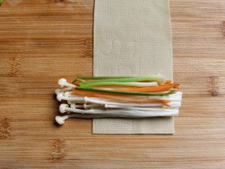 5、豆皮金针菇卷,取一张豆皮，方面放上金针菇，胡萝卜丝和香菜段，金针菇要多放一点，胡萝卜和香菜少放几根即可。