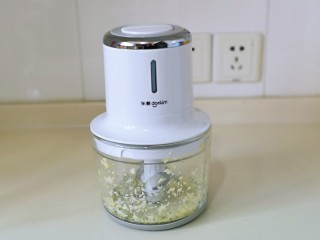 5、素鸡木耳炒虾仁,启动绞肉机将大蒜搅碎。