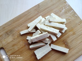 4、蒜薹炒豆腐,然后再切成豆腐条。豆腐条不要切的太细。切的太细，炒的时候易碎。