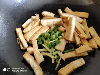 9、蒜薹炒豆腐,豆腐条煎好后，放入葱姜炒香。