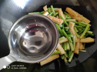 11、蒜薹炒豆腐,加入半炒勺热水翻炒。注意水不要加多了，少许的热水会使煎好的豆腐更加软嫩。水最好在没放蒜薹前加入，然后再放蒜薹。