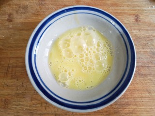 7、酥炸鱼翅南瓜丸子,鸡蛋磕入碗中打散成蛋液备用。